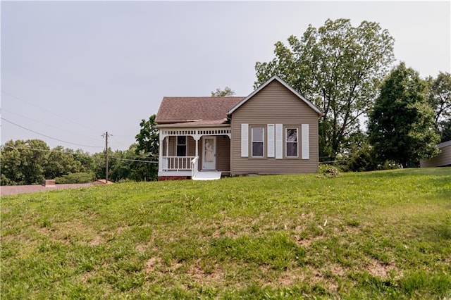 713 N 13th St, Atchison, KS 66002 - view of front of home featuring covered porch, a front lawn, and roof with shingles