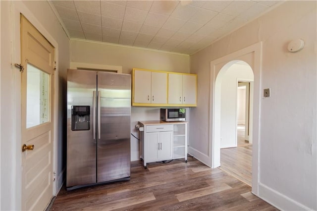 713 N 13th St, Atchison, KS 66002 - kitchen with appliances with stainless steel finishes, arched walkways, dark wood-type flooring, light countertops, and ornamental molding