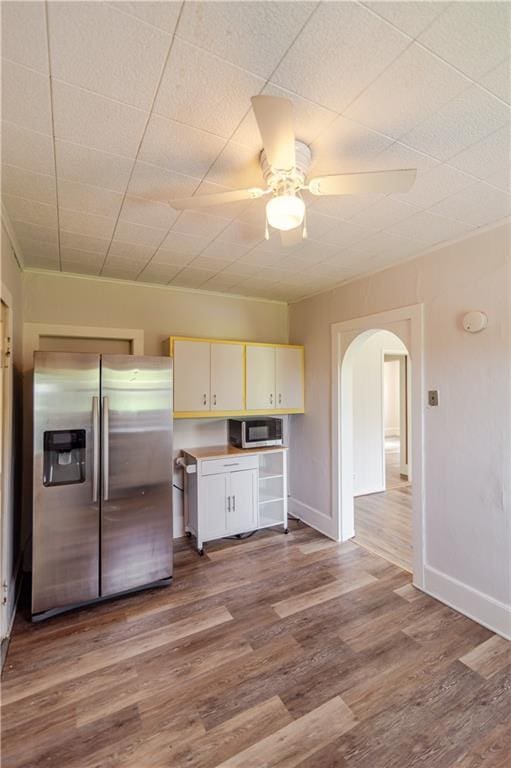 713 N 13th St, Atchison, KS 66002 - kitchen with appliances with stainless steel finishes, arched walkways, a ceiling fan, and wood finished floors