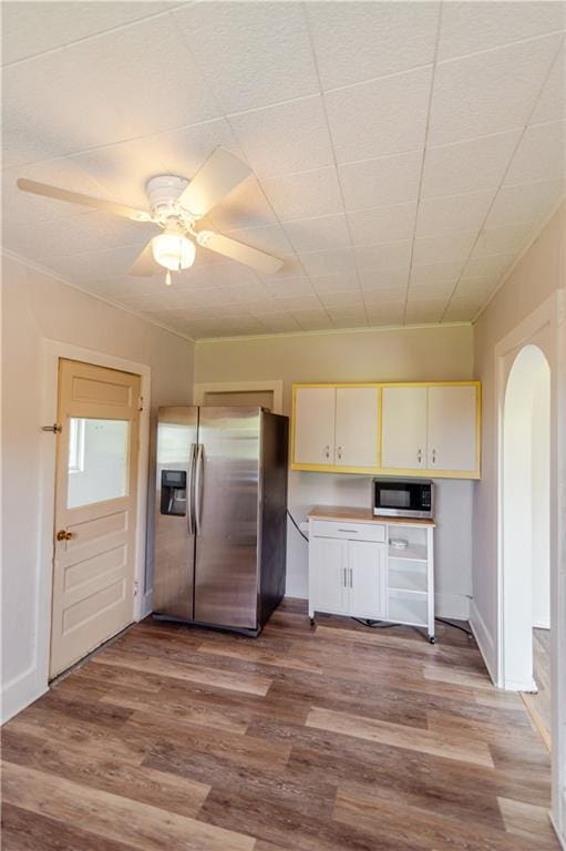 713 N 13th St, Atchison, KS 66002 - kitchen featuring appliances with stainless steel finishes, arched walkways, wood finished floors, and a ceiling fan