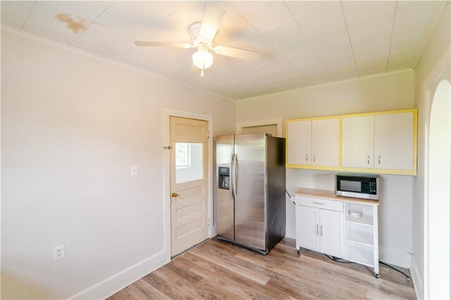 713 N 13th St, Atchison, KS 66002 - kitchen with appliances with stainless steel finishes, ornamental molding, light wood finished floors, cream cabinetry, and ceiling fan