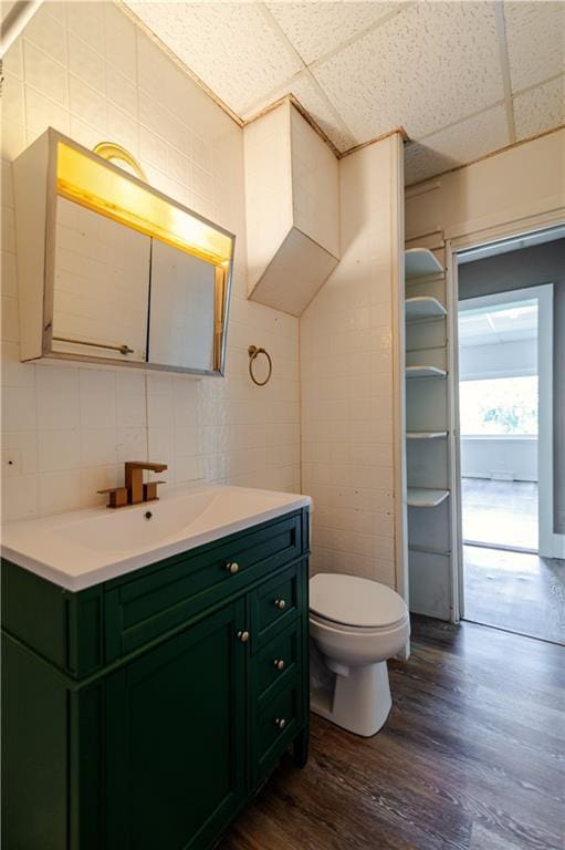 713 N 13th St, Atchison, KS 66002 - bathroom featuring a drop ceiling, vanity, wood finished floors, and backsplash