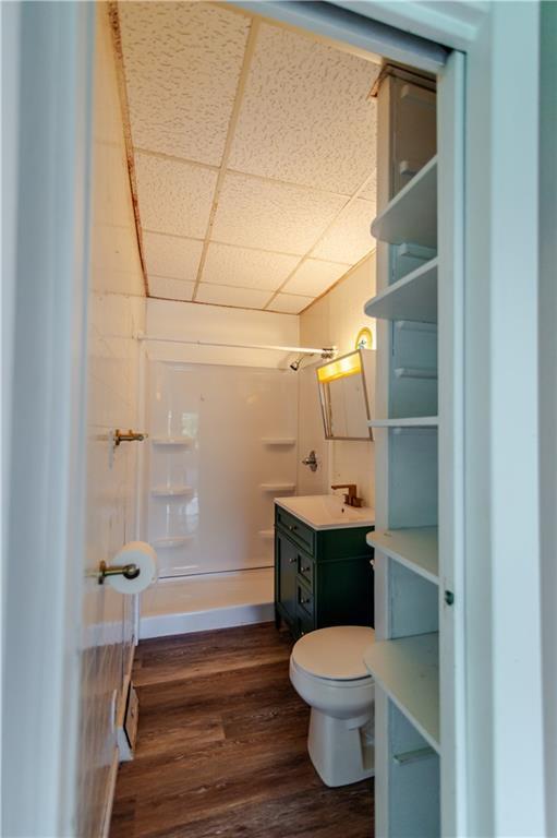 713 N 13th St, Atchison, KS 66002 - full bathroom with vanity, a shower, wood finished floors, and a drop ceiling