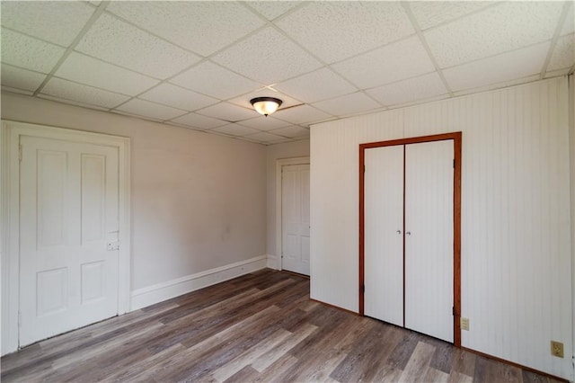 713 N 13th St, Atchison, KS 66002 - unfurnished bedroom with wood finished floors, a paneled ceiling, and a closet