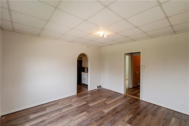 713 N 13th St, Atchison, KS 66002 - unfurnished room featuring arched walkways, a drop ceiling, and dark wood-style flooring