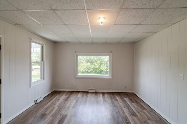 713 N 13th St, Atchison, KS 66002 - spare room featuring wood finished floors, a drop ceiling, and a baseboard radiator