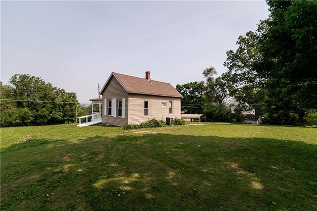 713 N 13th St, Atchison, KS 66002 - view of side of home featuring a lawn and a chimney