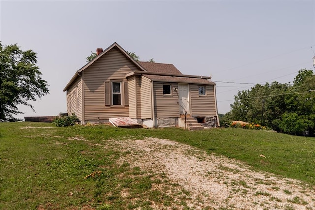 713 N 13th St, Atchison, KS 66002 - back of house with entry steps, a lawn, and a chimney
