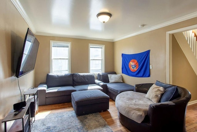 living area with hardwood / wood-style flooring, stairway, crown molding, and baseboards