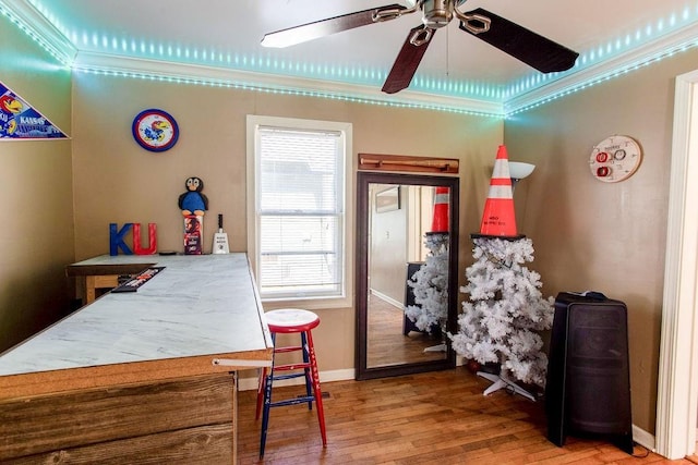 bedroom with a ceiling fan, crown molding, baseboards, and wood finished floors