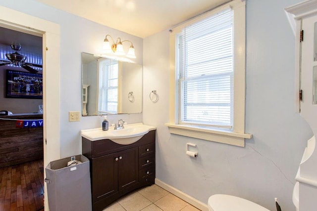 bathroom featuring a wealth of natural light, baseboards, toilet, and vanity