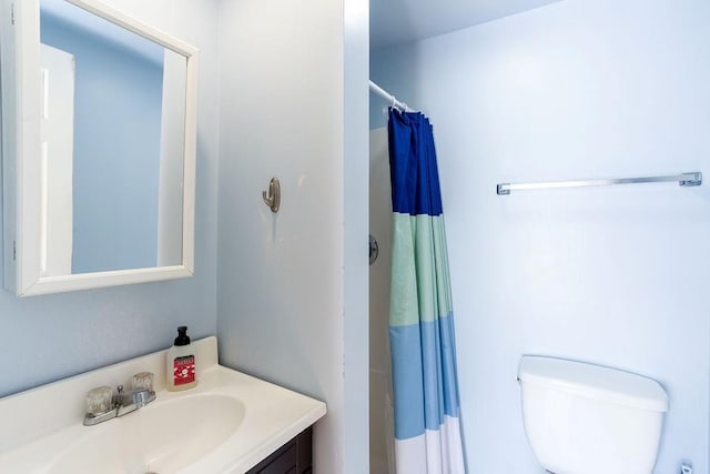 bathroom with curtained shower, toilet, and vanity