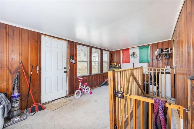 carpeted foyer with wooden walls