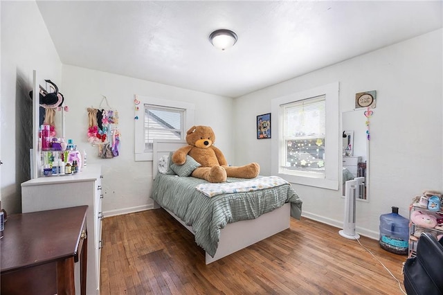 bedroom with hardwood / wood-style flooring and baseboards