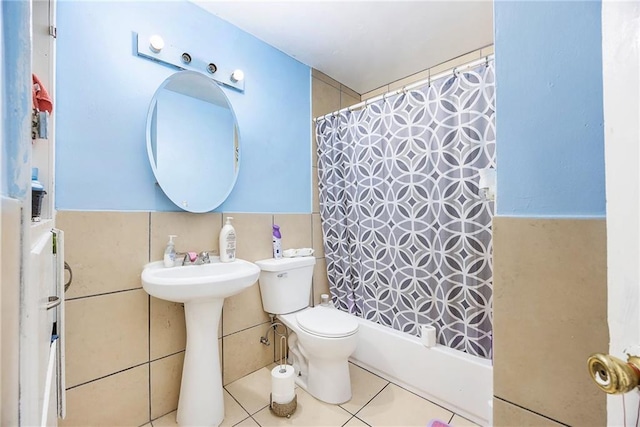 bathroom with tile patterned floors, shower / bathtub combination with curtain, toilet, and tile walls