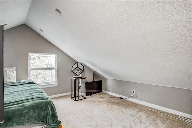 carpeted bedroom with visible vents, a textured ceiling, lofted ceiling, and baseboards