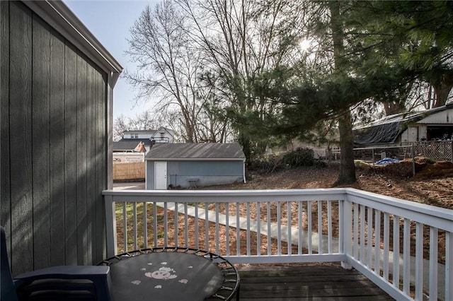 deck featuring fence, an outdoor structure, and a shed