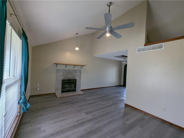 1900 SE 6th Ter, Lees Summit, MO 64063 - unfurnished living room with wood finished floors, a ceiling fan, high vaulted ceiling, a fireplace, and baseboards