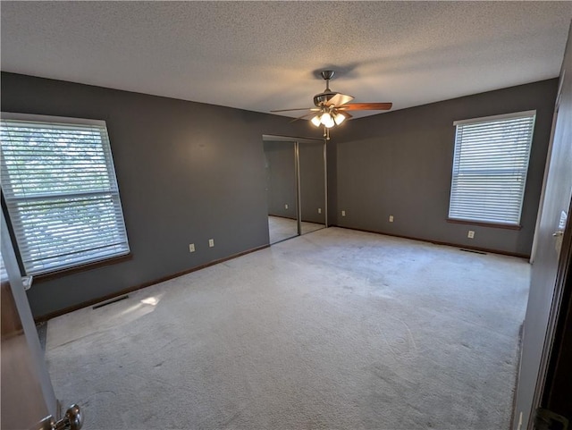 1900 SE 6th Ter, Lees Summit, MO 64063 - unfurnished bedroom featuring carpet flooring, a textured ceiling, baseboards, a ceiling fan, and a closet