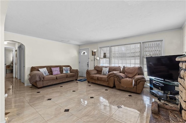 living area with arched walkways, a textured ceiling, marble finish floor, and crown molding