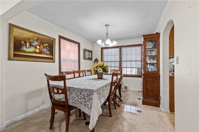 dining space featuring baseboards, arched walkways, an inviting chandelier, and crown molding