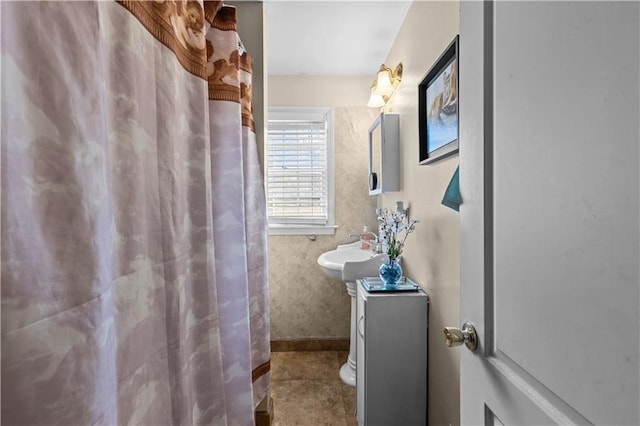 full bath featuring a sink, baseboards, and a shower with shower curtain