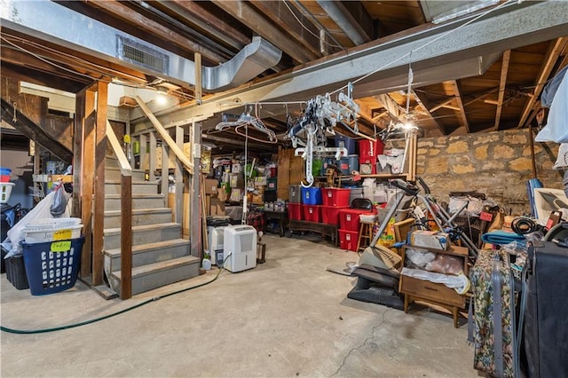 unfinished basement with stairs and visible vents