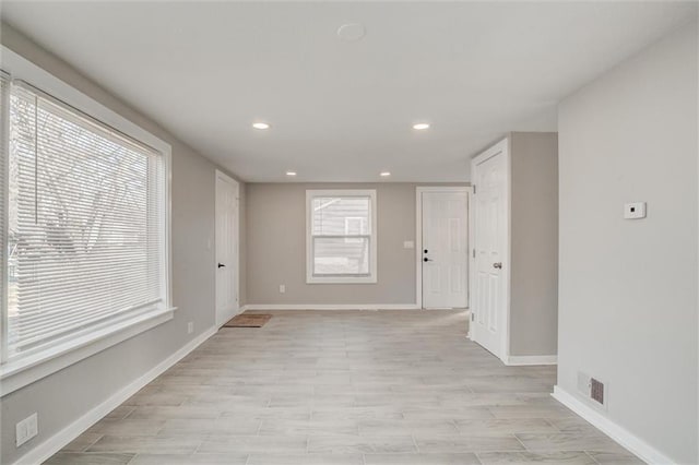 unfurnished room featuring recessed lighting, visible vents, baseboards, and a healthy amount of sunlight