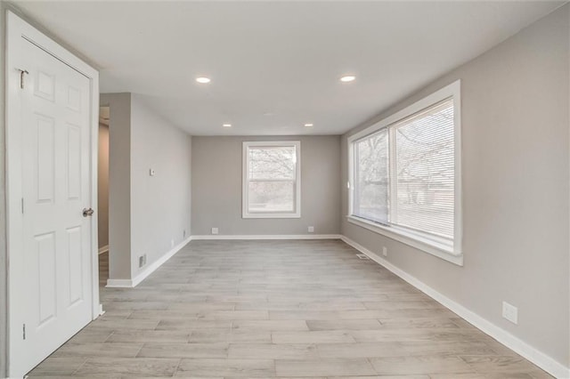 unfurnished room with recessed lighting, light wood-type flooring, and baseboards