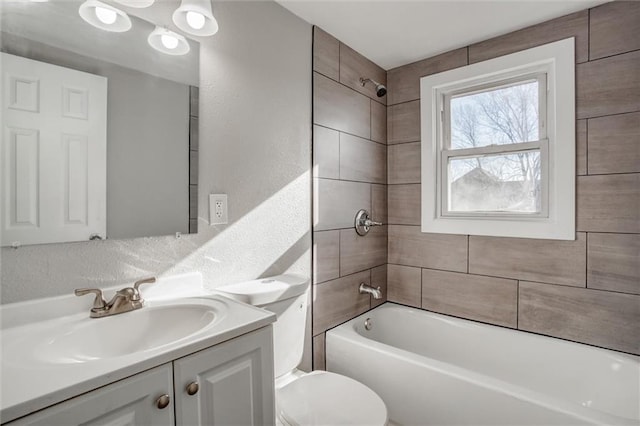 full bath with vanity, shower / tub combination, toilet, and a textured wall