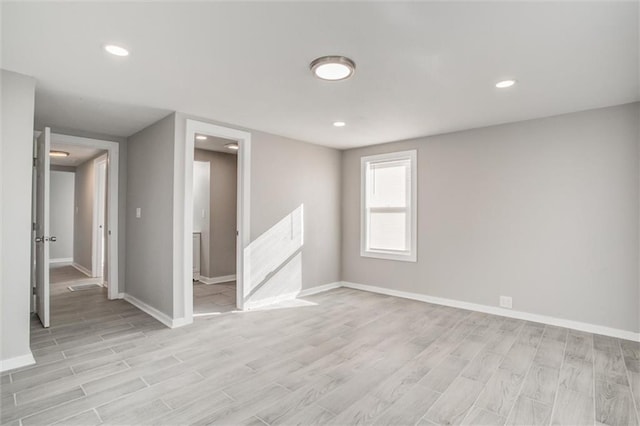 spare room with recessed lighting, baseboards, and light wood-style floors