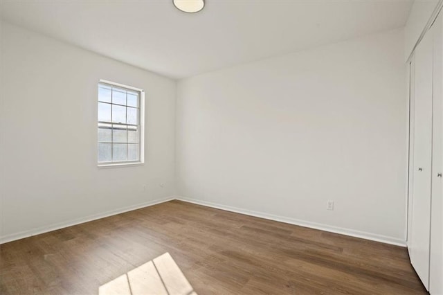 unfurnished room with wood finished floors and baseboards