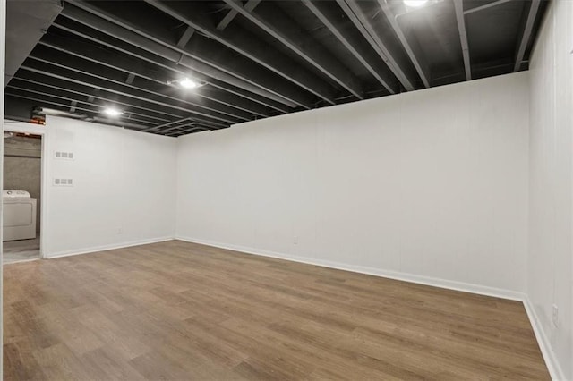 finished basement featuring washer and dryer and wood finished floors