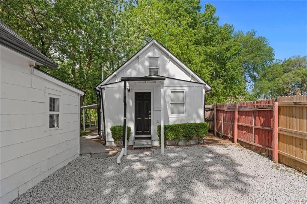 view of outbuilding featuring entry steps and fence