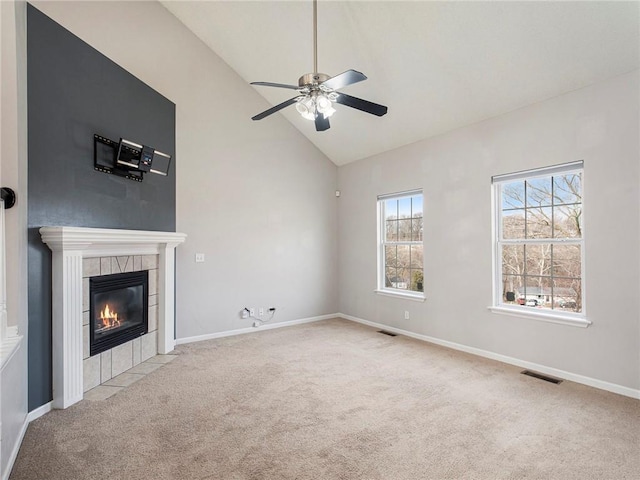 unfurnished living room featuring visible vents, baseboards, ceiling fan, carpet floors, and a tile fireplace