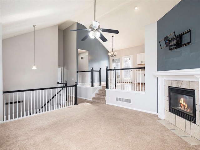 unfurnished living room featuring visible vents, ceiling fan with notable chandelier, carpet, a fireplace, and baseboards