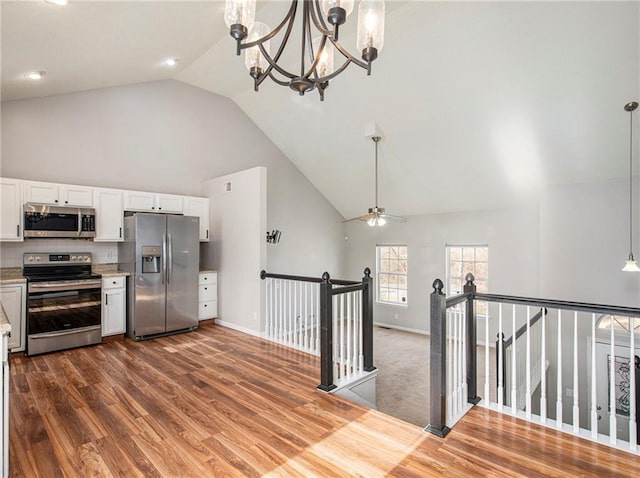 kitchen with white cabinetry, light countertops, wood finished floors, and stainless steel appliances