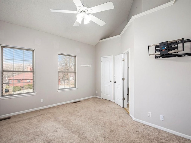 unfurnished bedroom with visible vents, baseboards, lofted ceiling, and carpet