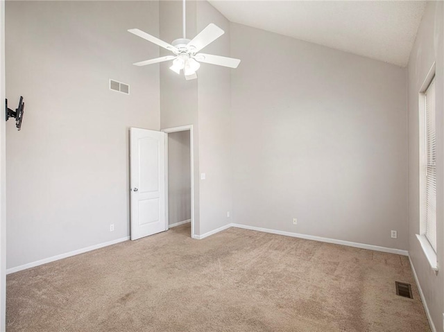 carpeted empty room with a ceiling fan, visible vents, and baseboards