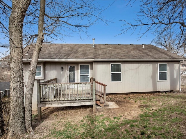 rear view of property featuring a wooden deck and a shingled roof