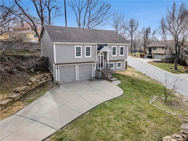 bi-level home with concrete driveway, a garage, and a front yard