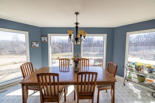 dining space featuring baseboards, plenty of natural light, a notable chandelier, and visible vents