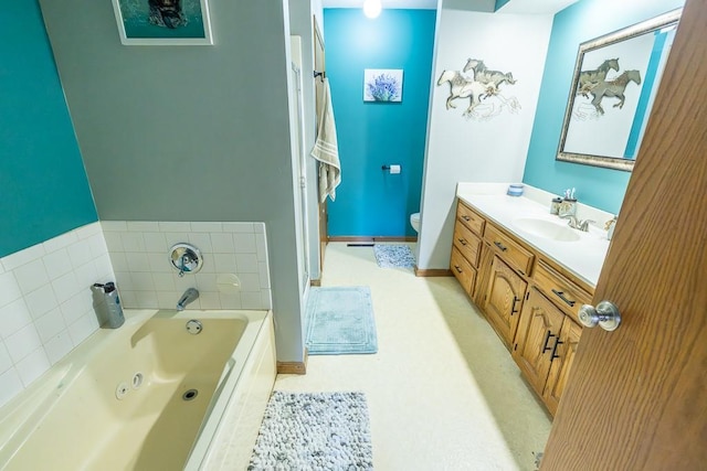 full bath with vanity, toilet, a tub with jets, and baseboards