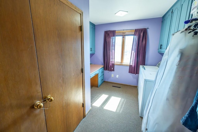 clothes washing area featuring visible vents, baseboards, washer / dryer, cabinet space, and light colored carpet