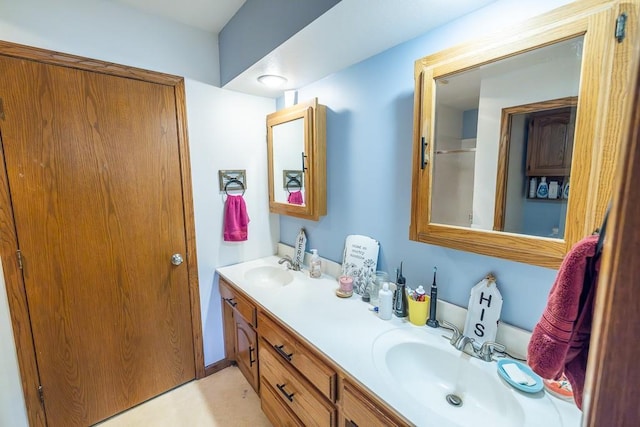 bathroom with a sink, a shower with door, and double vanity