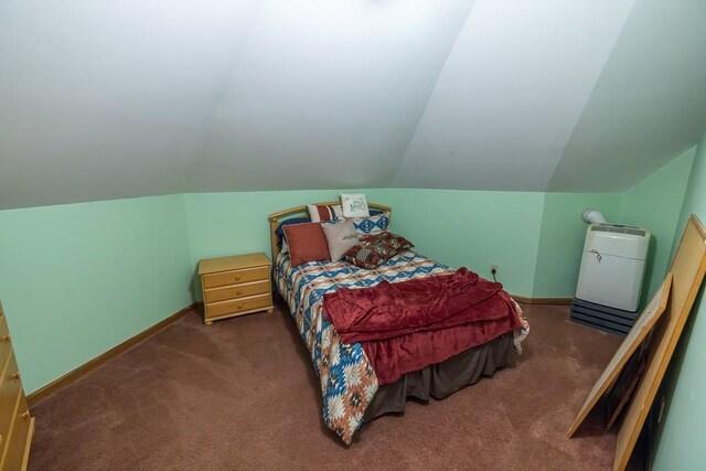 carpeted bedroom featuring lofted ceiling and baseboards