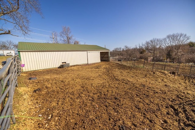 view of yard with an outdoor structure, a pole building, and fence