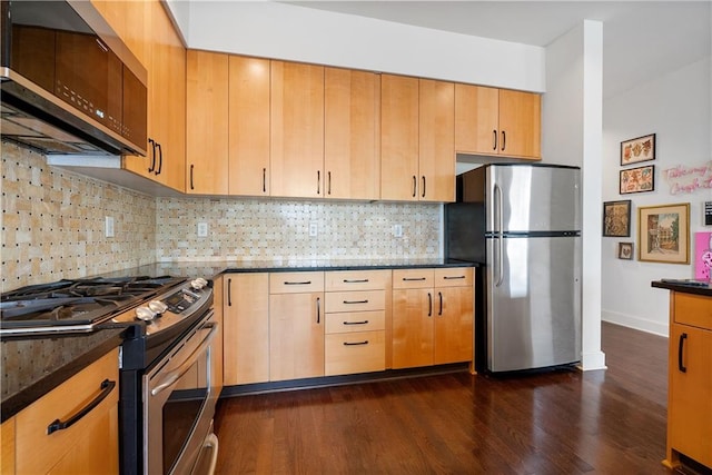 kitchen featuring dark stone counters, tasteful backsplash, dark wood-style flooring, and appliances with stainless steel finishes