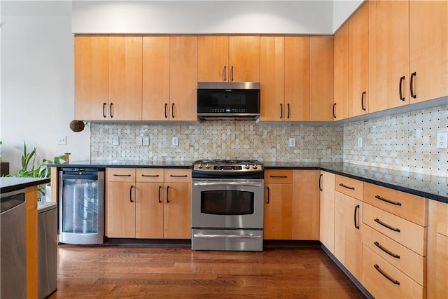 kitchen featuring wine cooler, dark wood finished floors, light brown cabinetry, dark stone counters, and stainless steel appliances