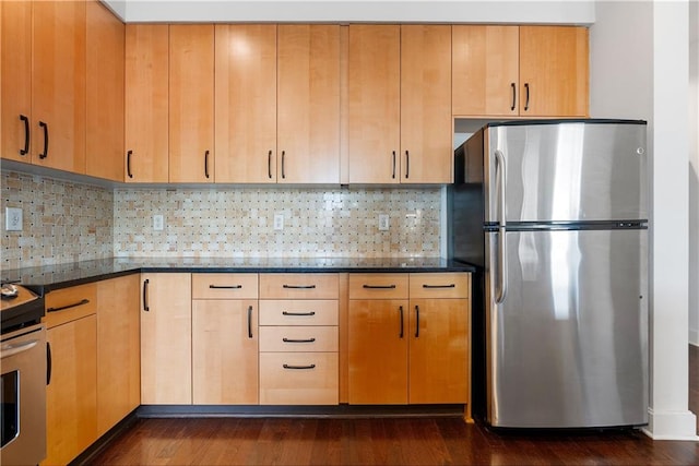 kitchen with light brown cabinets, dark wood-style floors, dark stone counters, appliances with stainless steel finishes, and tasteful backsplash